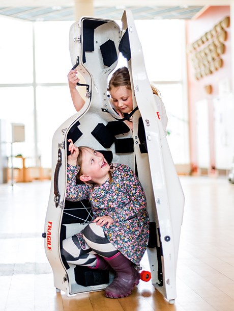 Två barn leker i ett cellofodral